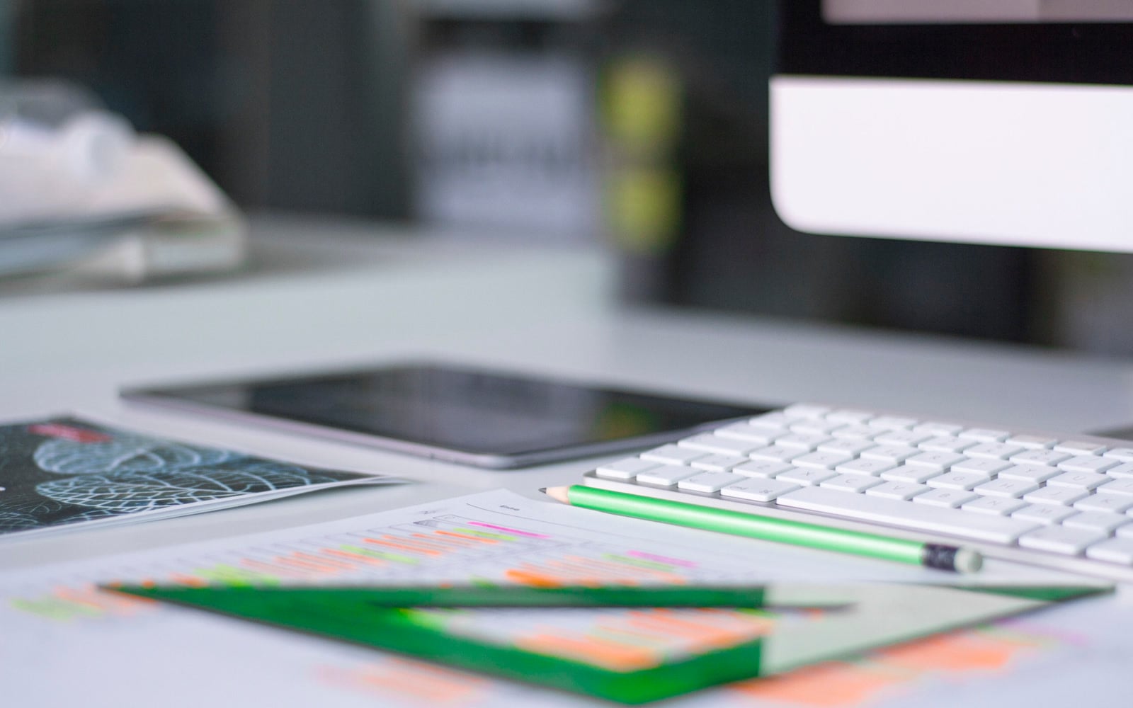 A keyboard and writing materials on an office desk