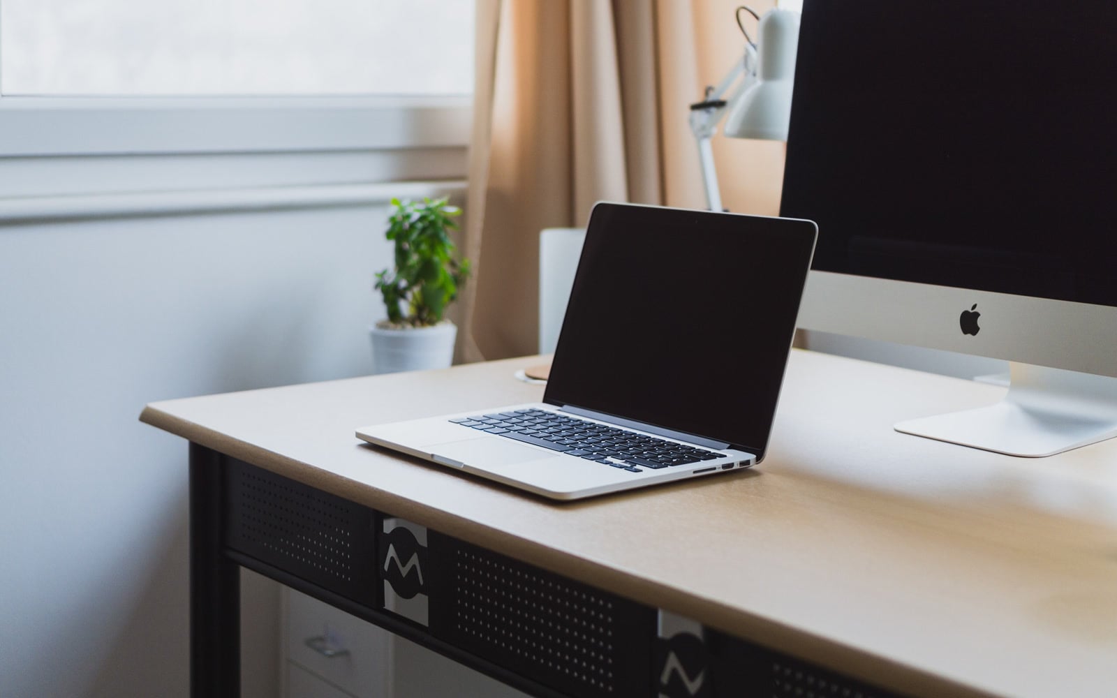 A laptop and monitor on an uncluttered desk
