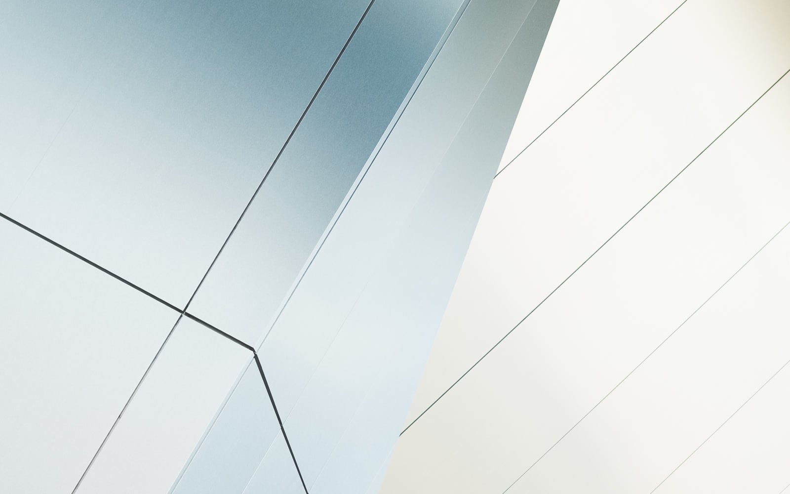 Sunlight crosses the white panels of a modern building