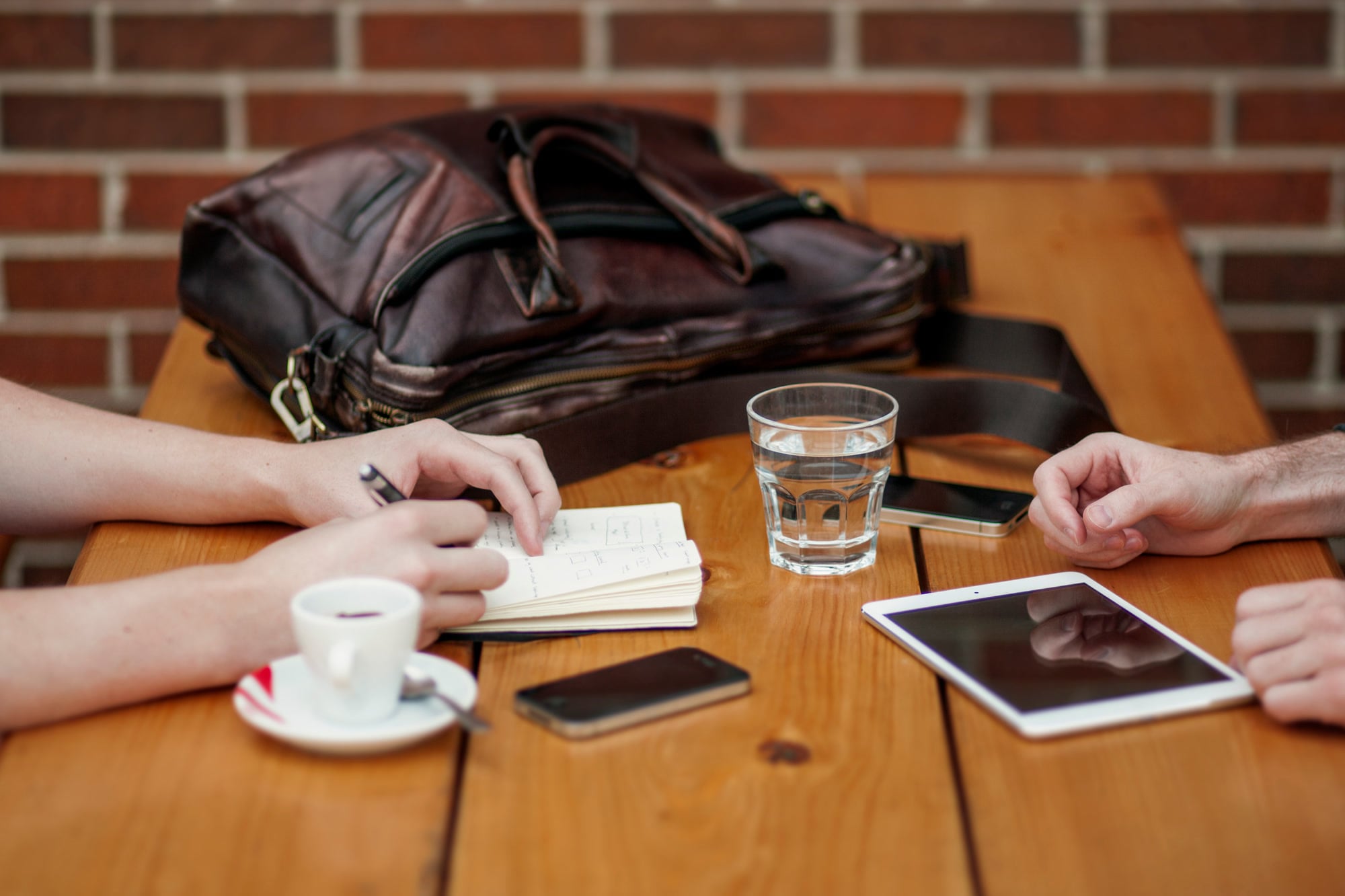 Two people compare notes and digital references at a table